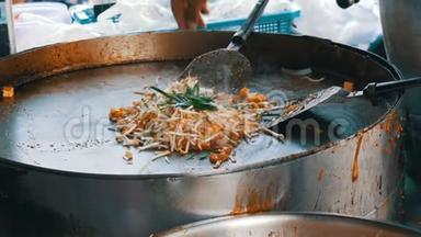 卖街食品的人用鸡蛋、鸡肉和芽炒传统泰国米粉。 亚洲街头食品